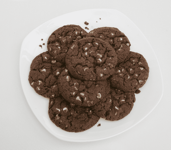 nicely arranged Chocolate Cookies with white chocolate chips on a white plate.